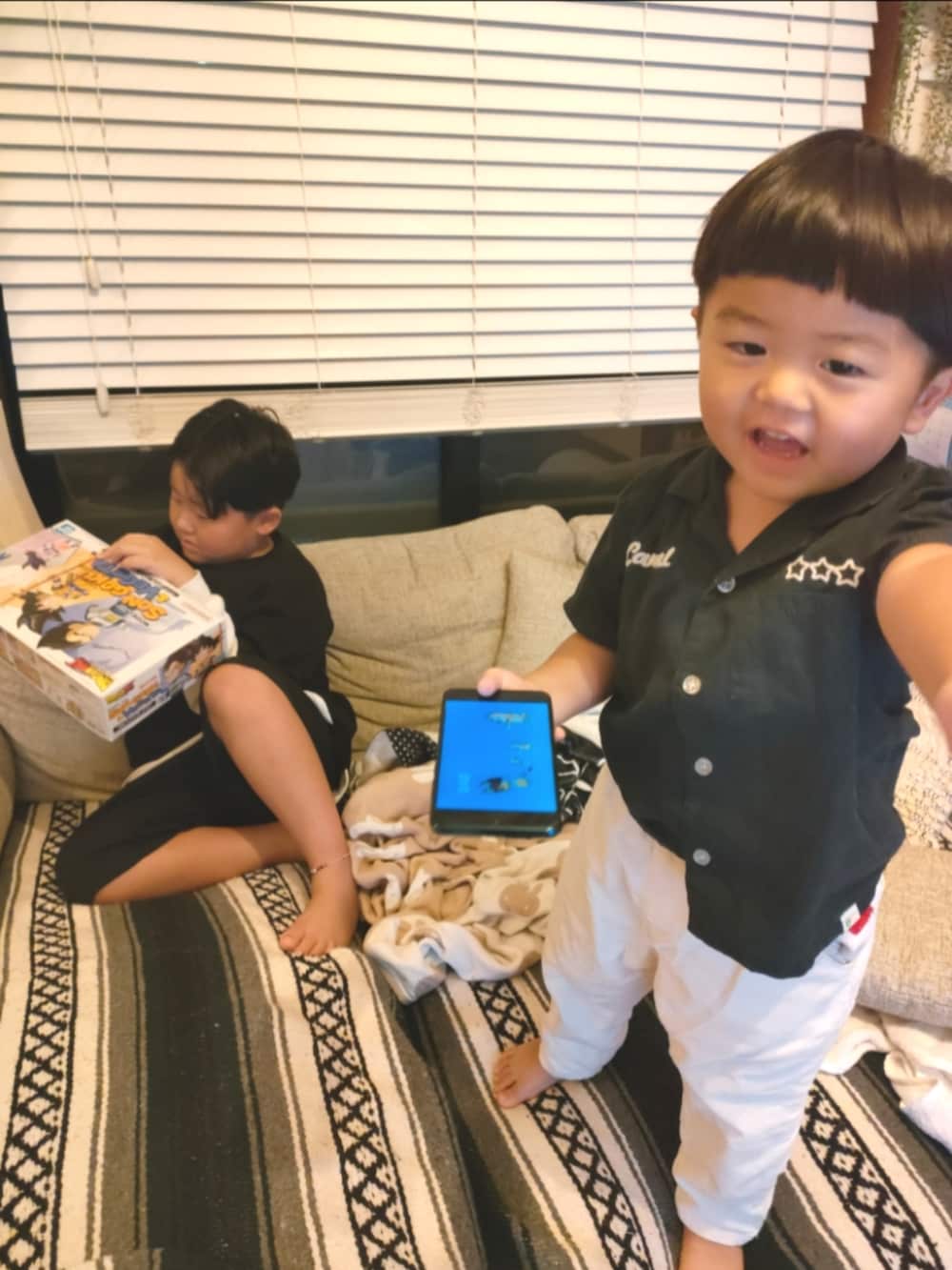ブラック系のTシャツ/カットソー、ブラック系のパンツ、ブラック系のスニーカーを着用したキッズの秋コーディネートの4枚目の写真