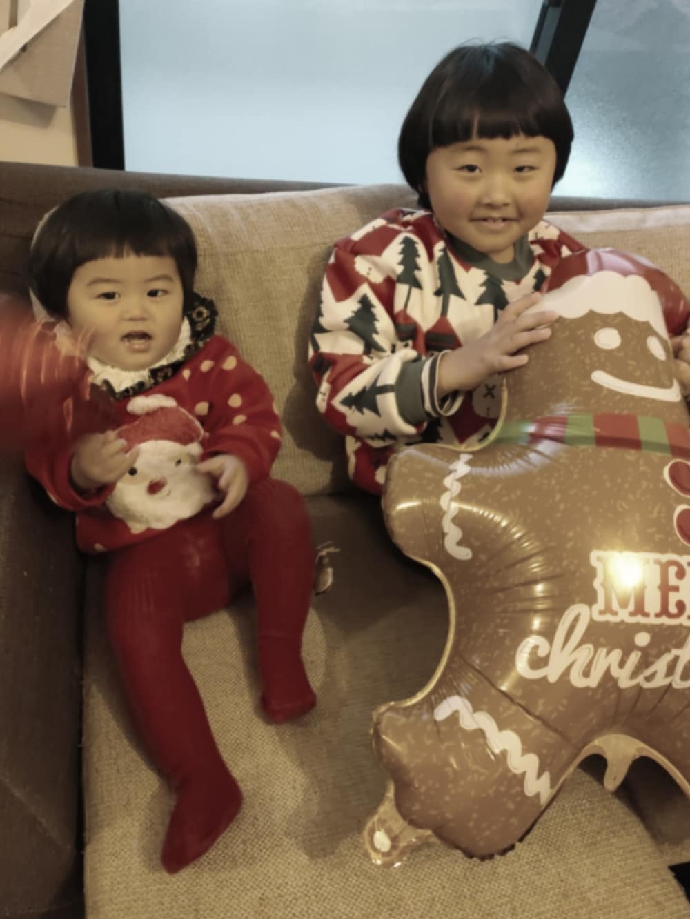 レッド系のロンパース、グリーン系のスタイ/よだれかけ、レッド系のベビーシューズ/ベビーソックスを着用したキッズの冬コーディネートの5枚目の写真