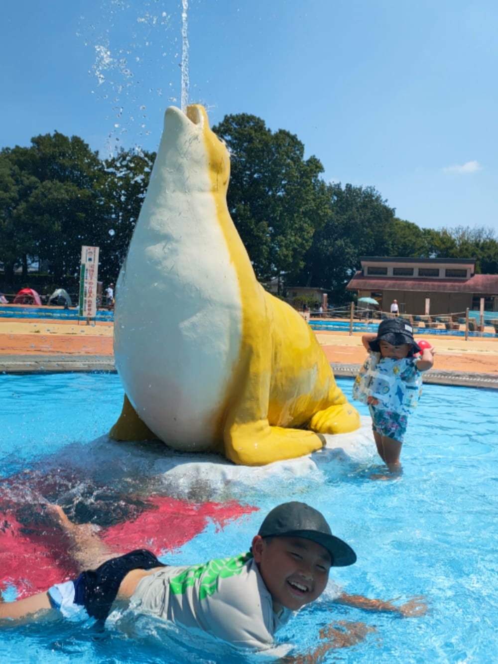 グレー系のTシャツ/カットソー、ブラック系のハット、ホワイト系のスイムグッズを着用したキッズの秋コーディネートの3枚目の写真