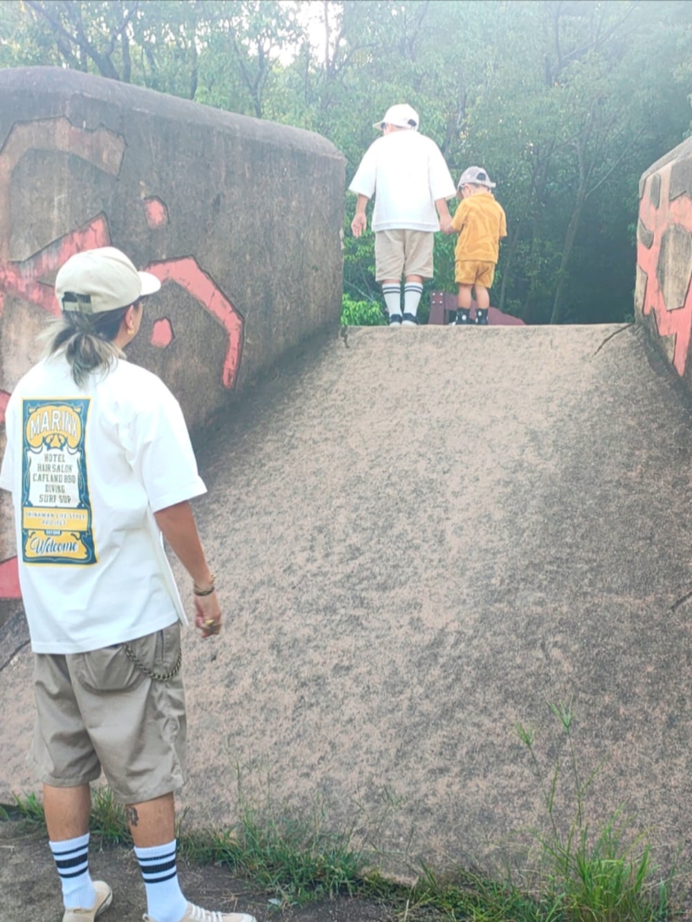 ホワイト系のTシャツ/カットソー、ブラック系のスニーカー、ベージュ系のパンツを着用したキッズの秋コーディネートの5枚目の写真