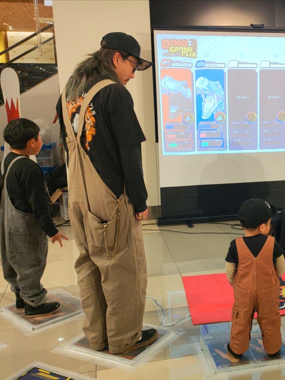 ブラック系のTシャツ/カットソー、グレー系のサロペット/オーバーオール、ブラック系のトップスを着用したキッズの春コーディネートの2枚目の写真