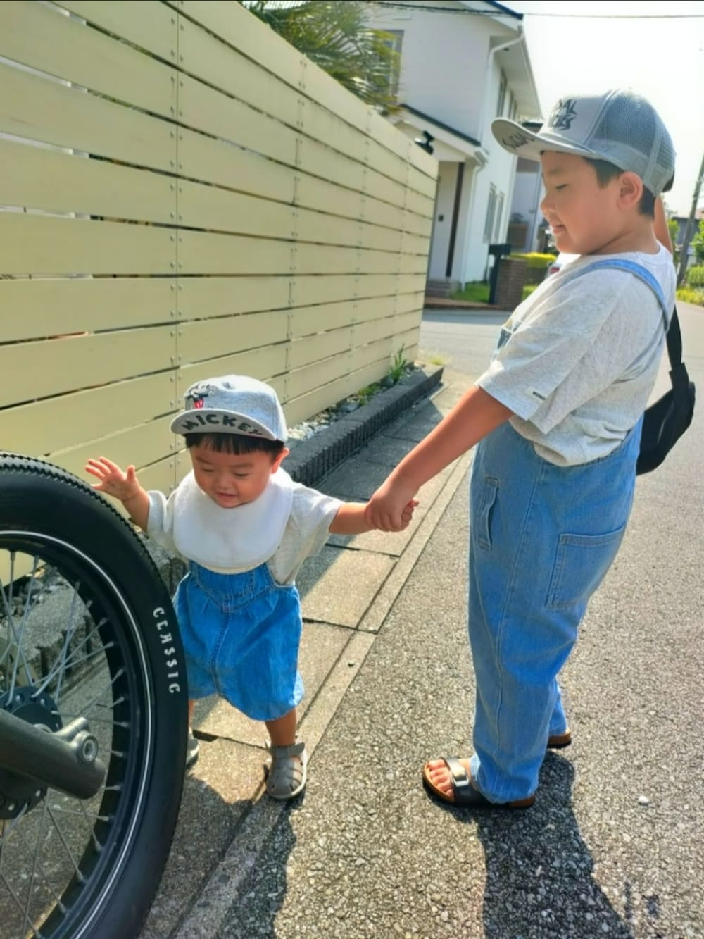 ブルー系のサロペット/オーバーオール、グレー系のTシャツ/カットソー、ブルー系のオールインワン・サロペットを着用したキッズの秋コーディネートの3枚目の写真