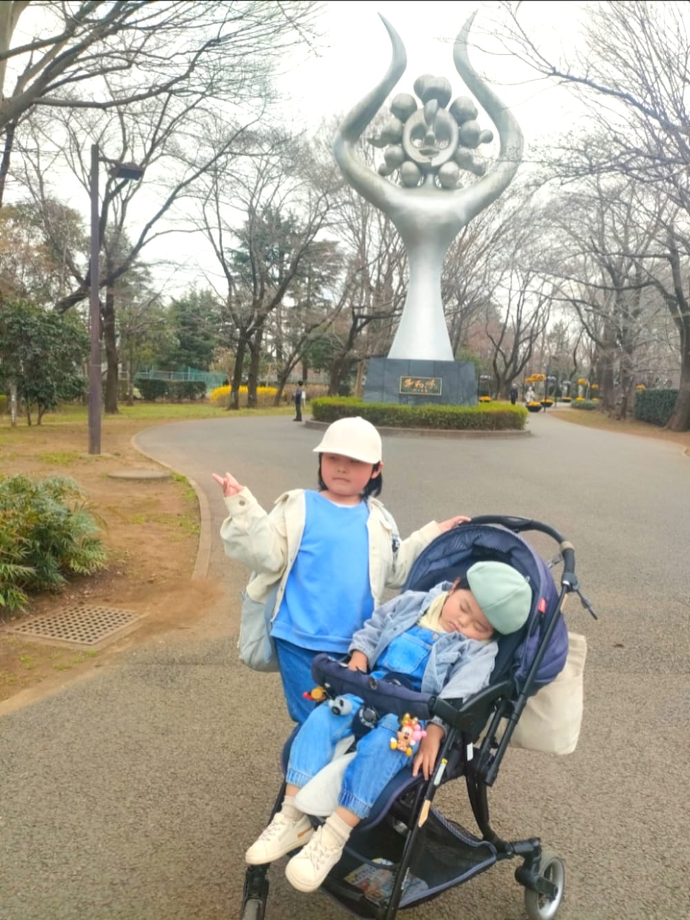 ブルー系のスウェット、ブルー系のデニムパンツ、ベージュ系のパーカーを着用したキッズの春コーディネートの3枚目の写真