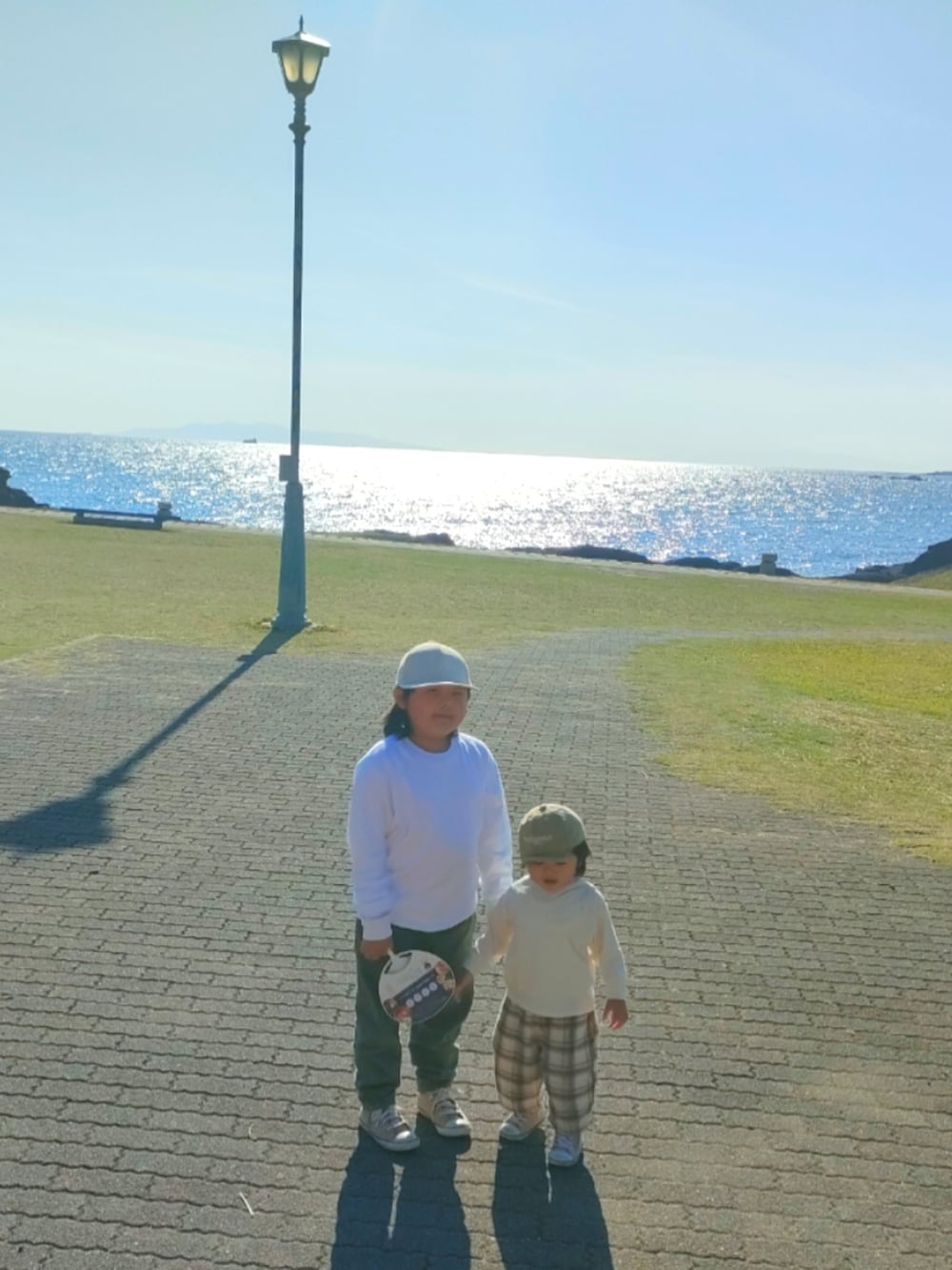 ベージュ系のスニーカー、ホワイト系のTシャツ/カットソー、ホワイト系のパンツを着用したキッズの春コーディネートの3枚目の写真