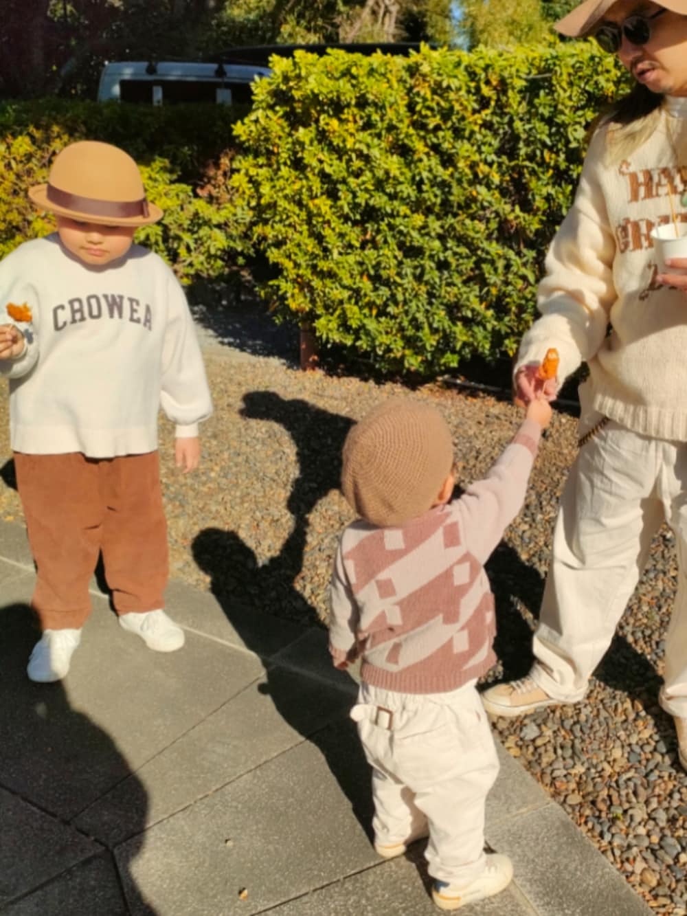 ブラウン系のカーディガン/ボレロ、ホワイト系のスニーカー、ブラウン系のセットアップを着用したキッズの冬コーディネートの4枚目の写真