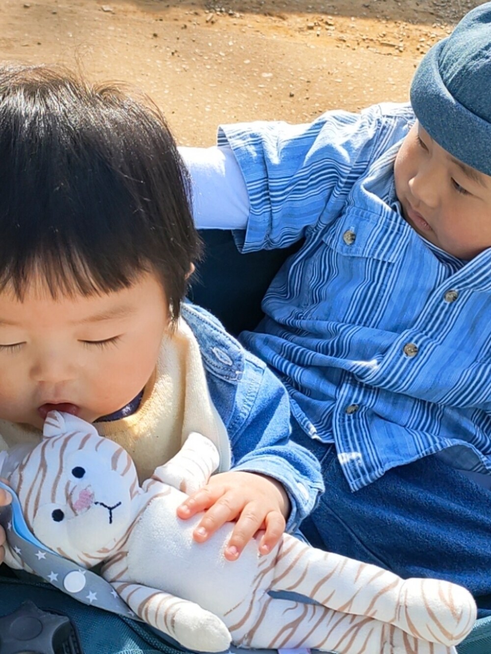 ブルー系のデニムパンツ、ブラック系のスニーカー、ブルー系のシャツ/ブラウスを着用したキッズの春コーディネートの2枚目の写真
