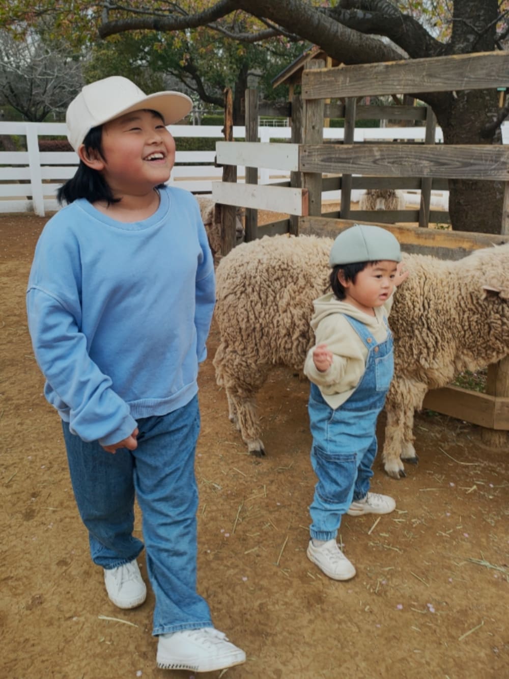 ブルー系のスウェット、ブルー系のデニムパンツ、ベージュ系のパーカーを着用したキッズの春コーディネートの4枚目の写真