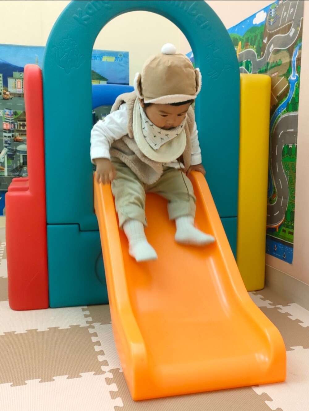 ベージュ系のベスト、ホワイト系のスニーカー、ベージュ系のパンツを着用したキッズの秋コーディネートの4枚目の写真