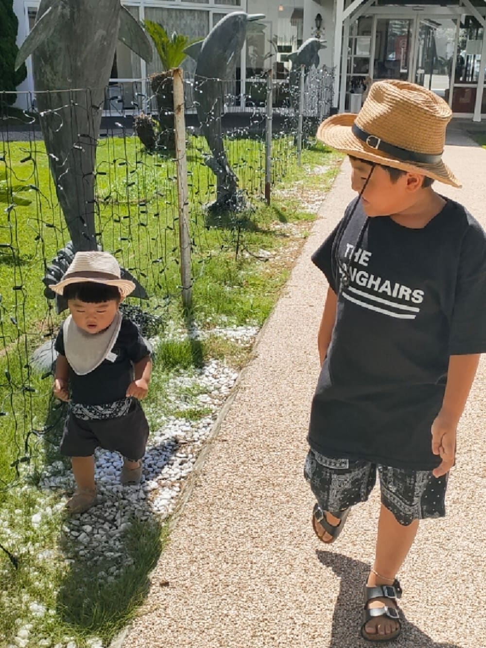 ブラック系のTシャツ/カットソー、ブラック系のパンツ、ブラック系のサンダルを着用したキッズの秋コーディネートの2枚目の写真