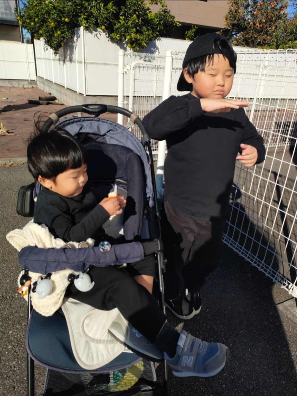 ブラック系のTシャツ/カットソー、ブラック系のパンツ、ブラック系のスリッポンを着用したキッズの秋コーディネートの2枚目の写真