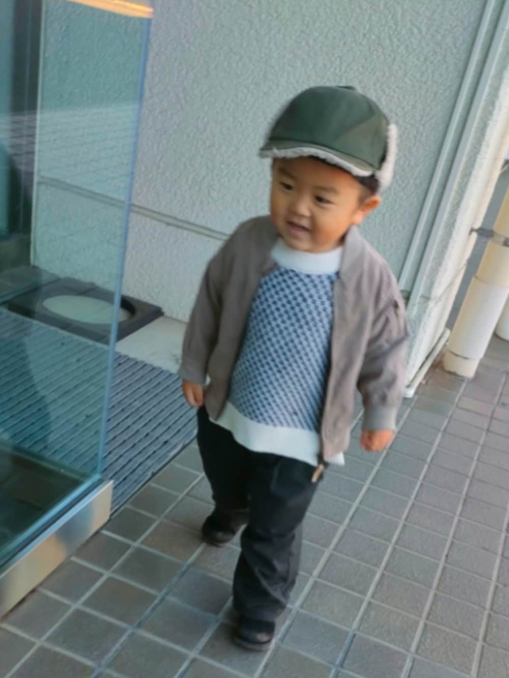 ホワイト系のカーディガン/ボレロ、ブラック系のパンツ、ブラック系のブーツを着用したキッズの冬コーディネートの4枚目の写真