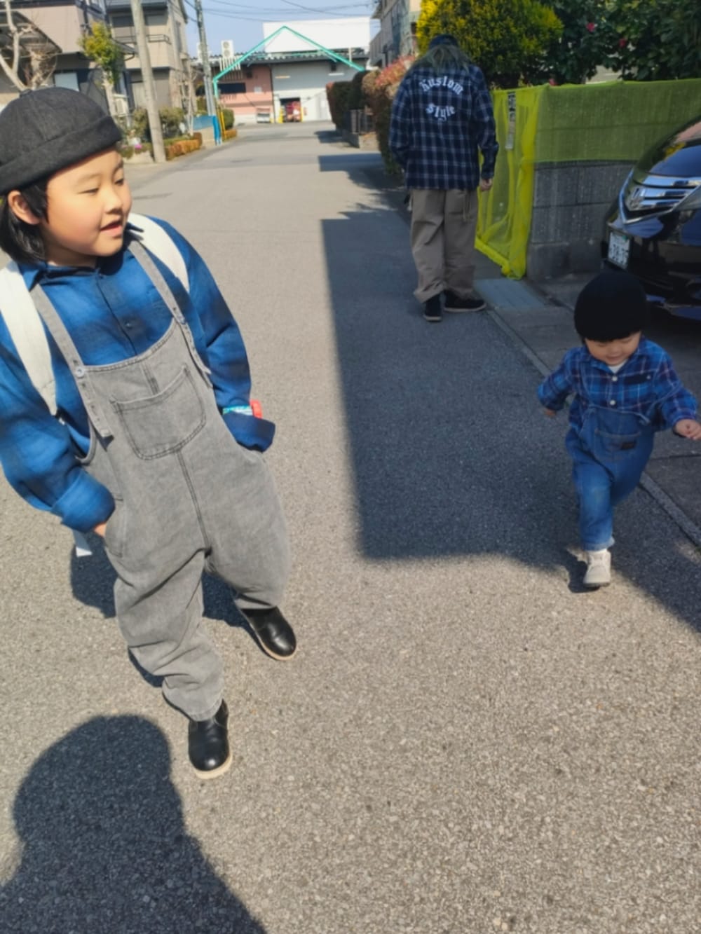 ブルー系のシャツ/ブラウス、ブルー系のサロペット/オーバーオール、グレー系のブーツを着用したキッズの春コーディネートの3枚目の写真