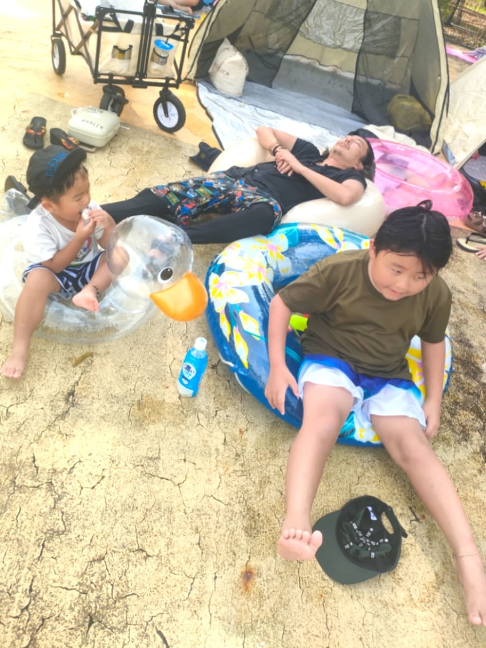 グリーン系の帽子、グリーン系のラッシュガード、ブルー系の水着/着物・浴衣を着用したキッズの夏コーディネートの3枚目の写真