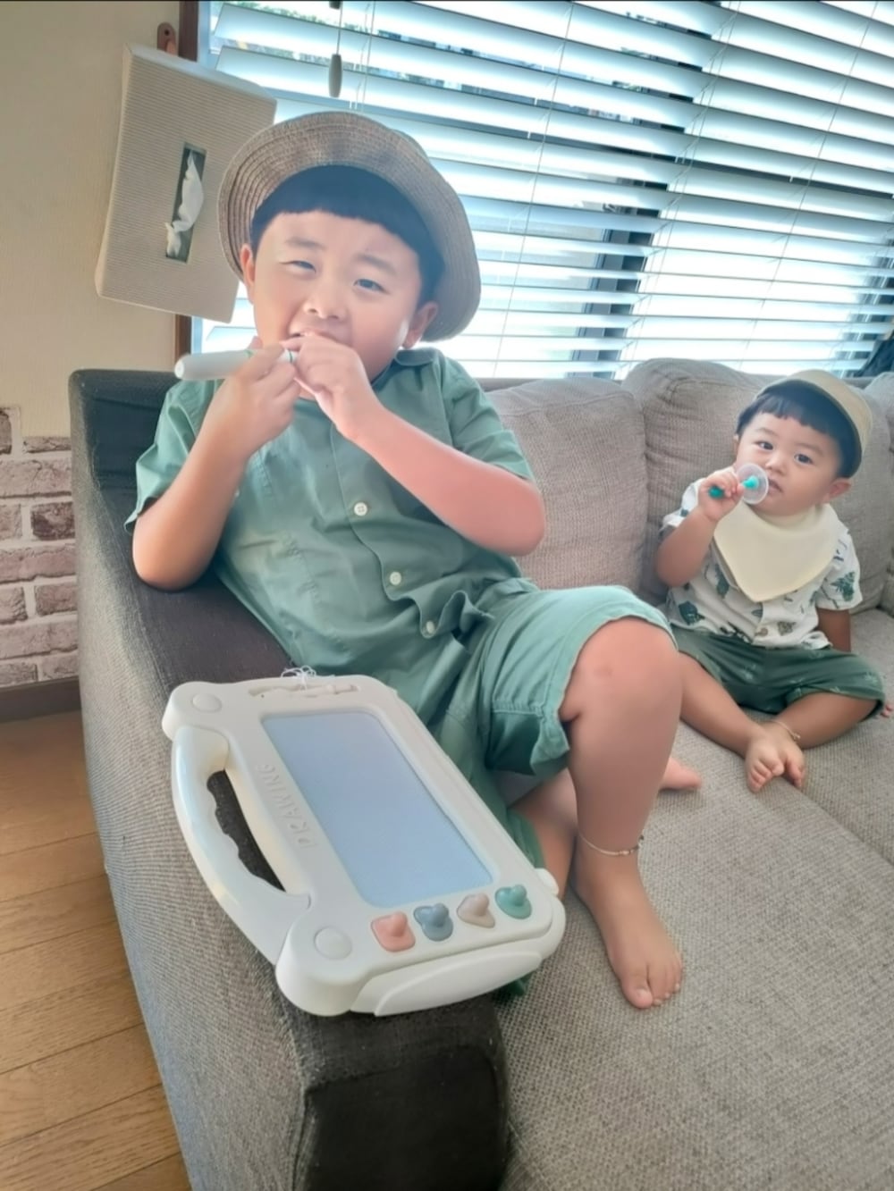 グリーン系のパンツ、ブラウン系のサンダル、グリーン系のシャツ/ブラウスを着用したキッズの夏コーディネートの2枚目の写真