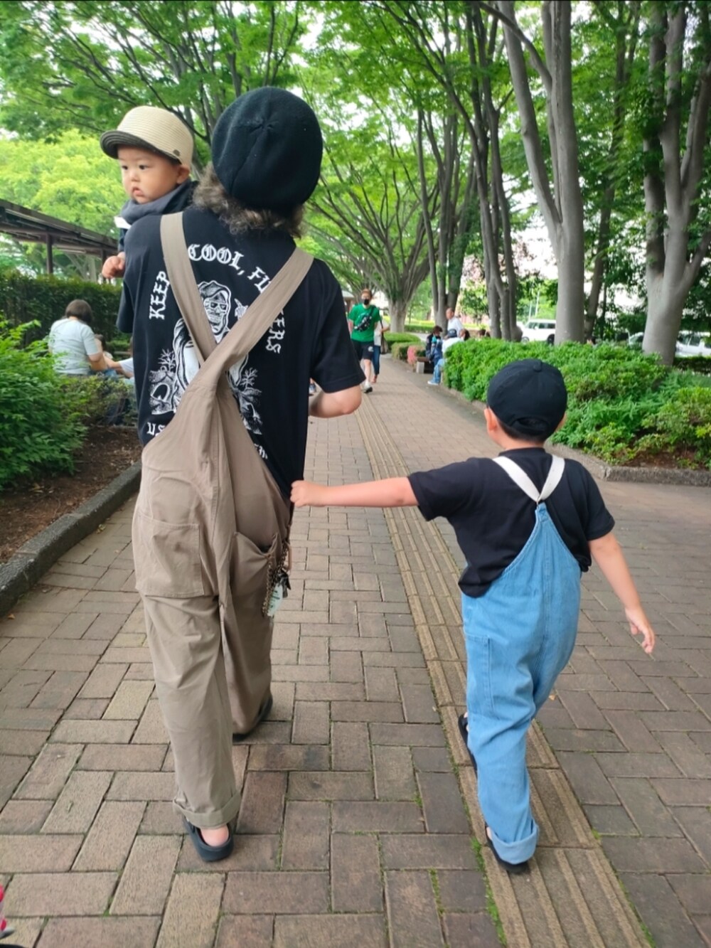 ブラック系のTシャツ/カットソー、ブラック系のサンダル、ブルー系のサロペット/オーバーオールを着用したキッズの春コーディネートの3枚目の写真