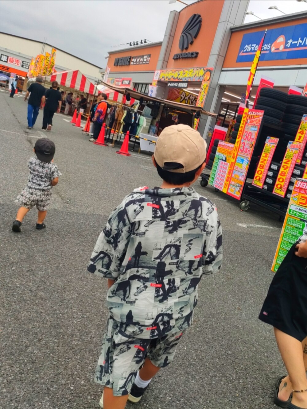 ブラック系のサンダル、グレー系のセットアップ、グレー系のキャップを着用したキッズの夏コーディネートの2枚目の写真