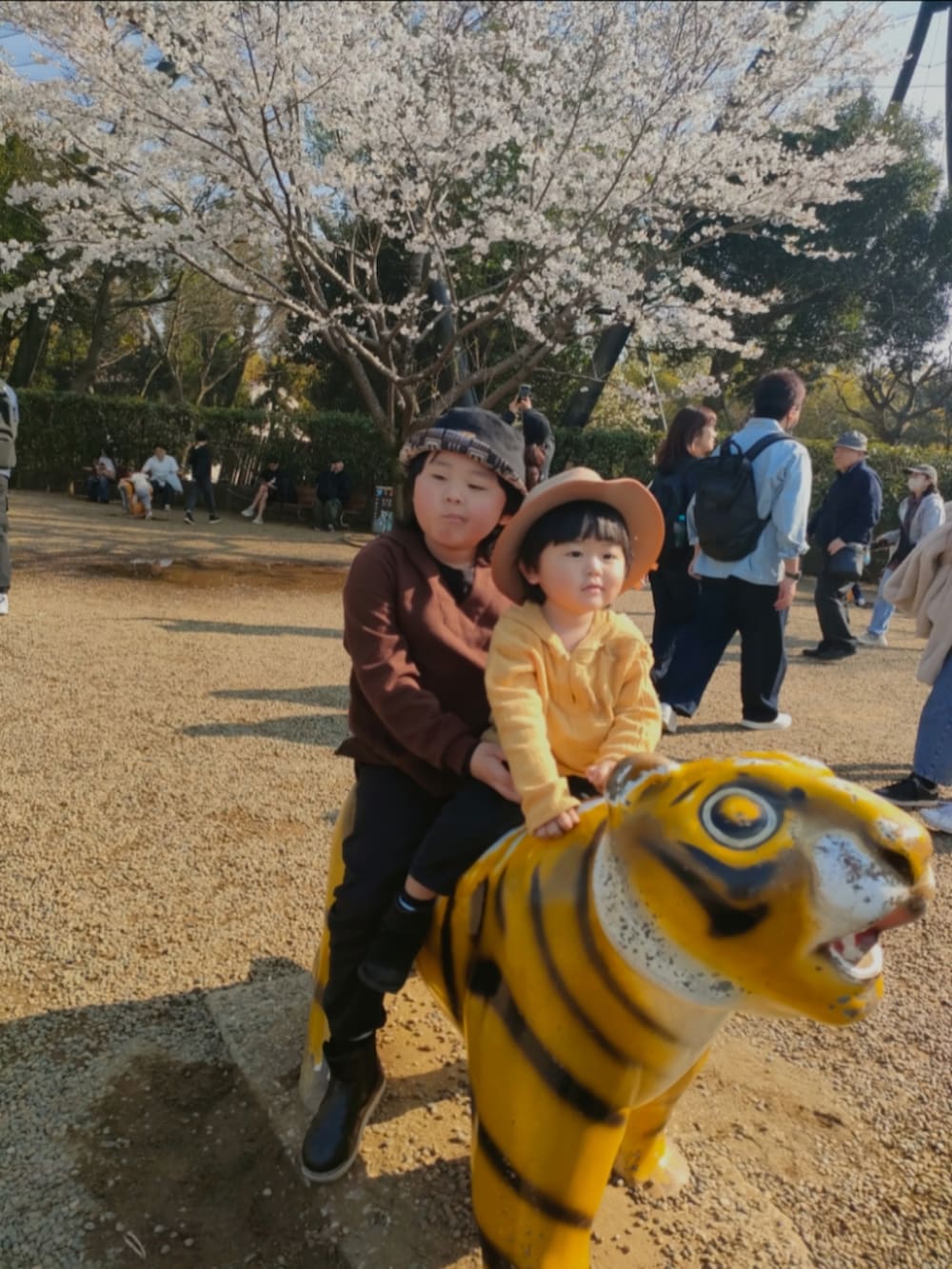 ブラウン系のパーカー、ブラック系のパンツ、ブラック系のブーツを着用したキッズの春コーディネートの3枚目の写真