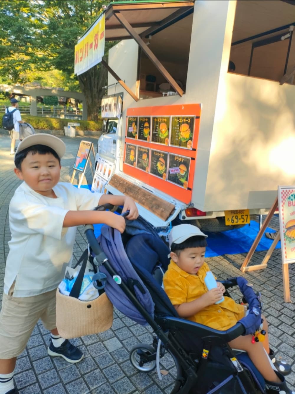 ホワイト系のTシャツ/カットソー、ブラック系のスニーカー、ベージュ系のパンツを着用したキッズの秋コーディネートの2枚目の写真