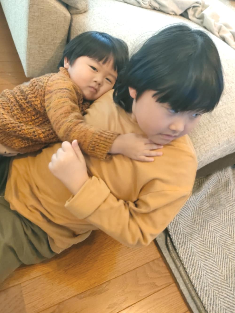 オレンジ系のニット/セーター、ブラック系のパンツ、ブラック系のレインシューズを着用したキッズの春コーディネートの5枚目の写真