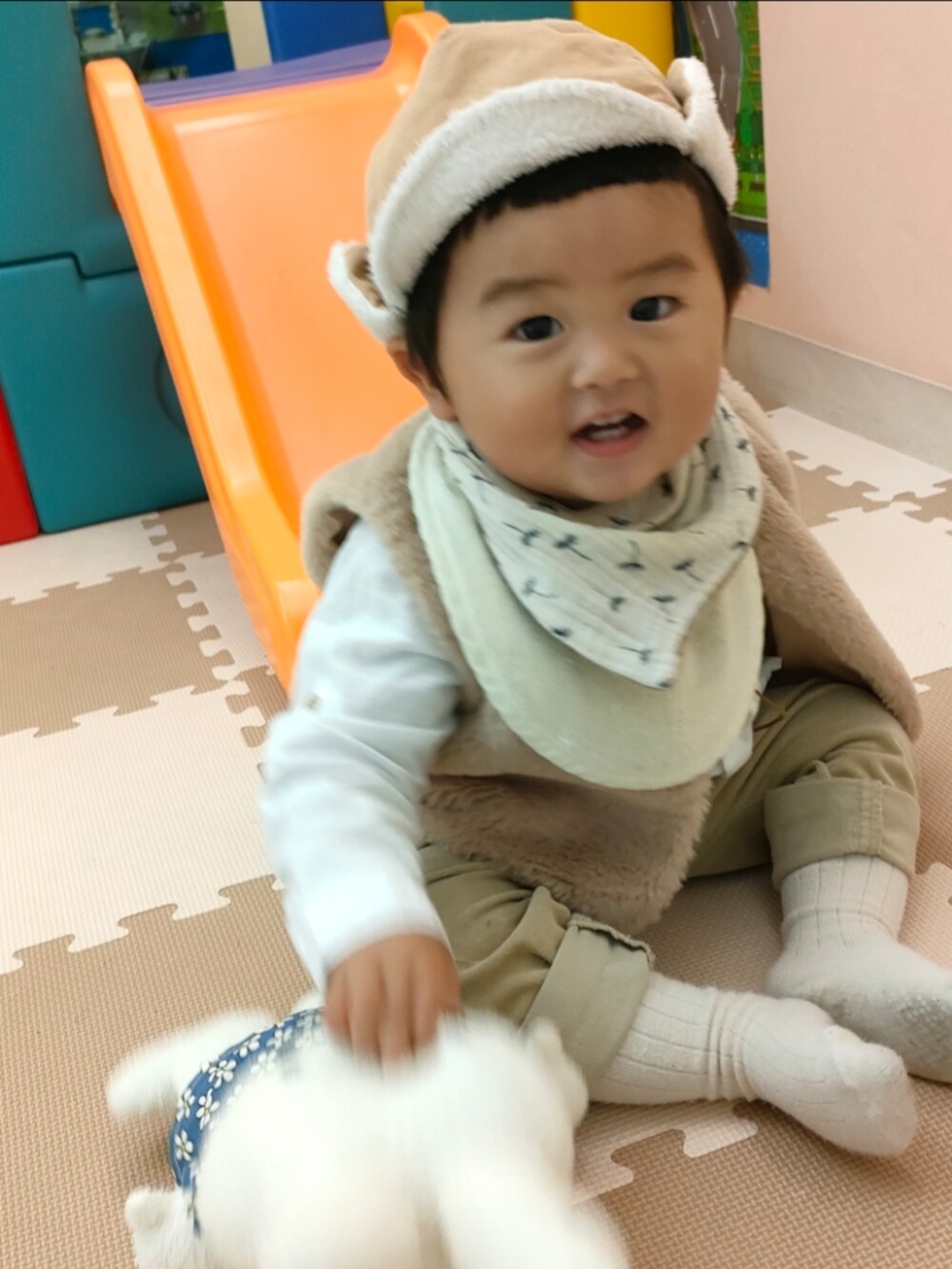 ベージュ系のベスト、ホワイト系のスニーカー、ベージュ系のパンツを着用したキッズの秋コーディネートの5枚目の写真