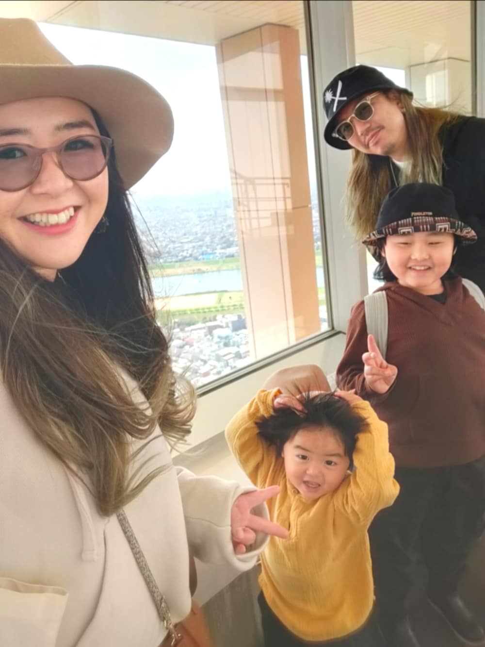 ブラウン系のパーカー、ブラック系のパンツ、ブラック系のブーツを着用したキッズの春コーディネートの5枚目の写真