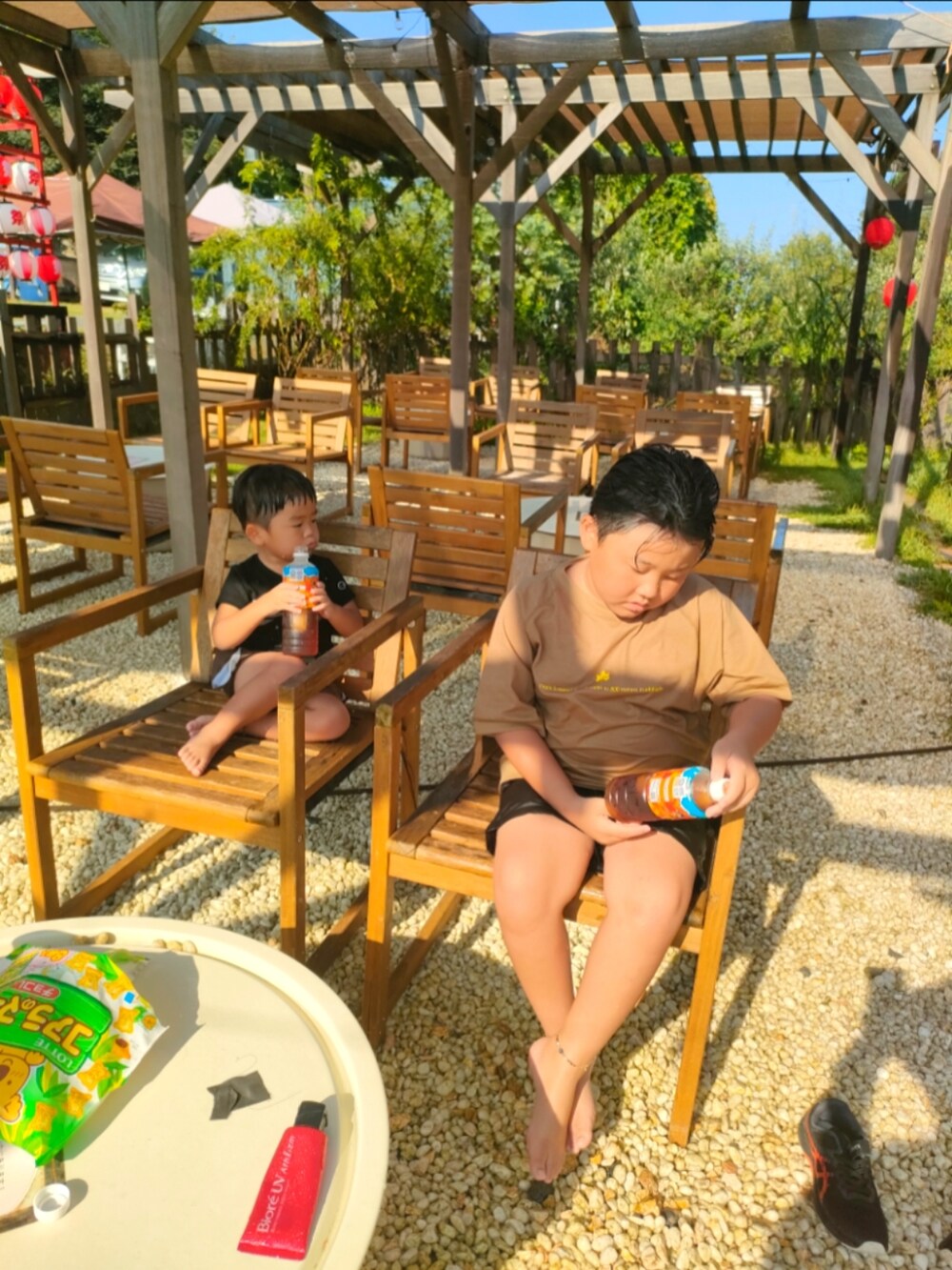 ブラック系のTシャツ/カットソー、ブラウン系の水着、ベージュ系のラッシュガードを着用したキッズの夏コーディネートの2枚目の写真