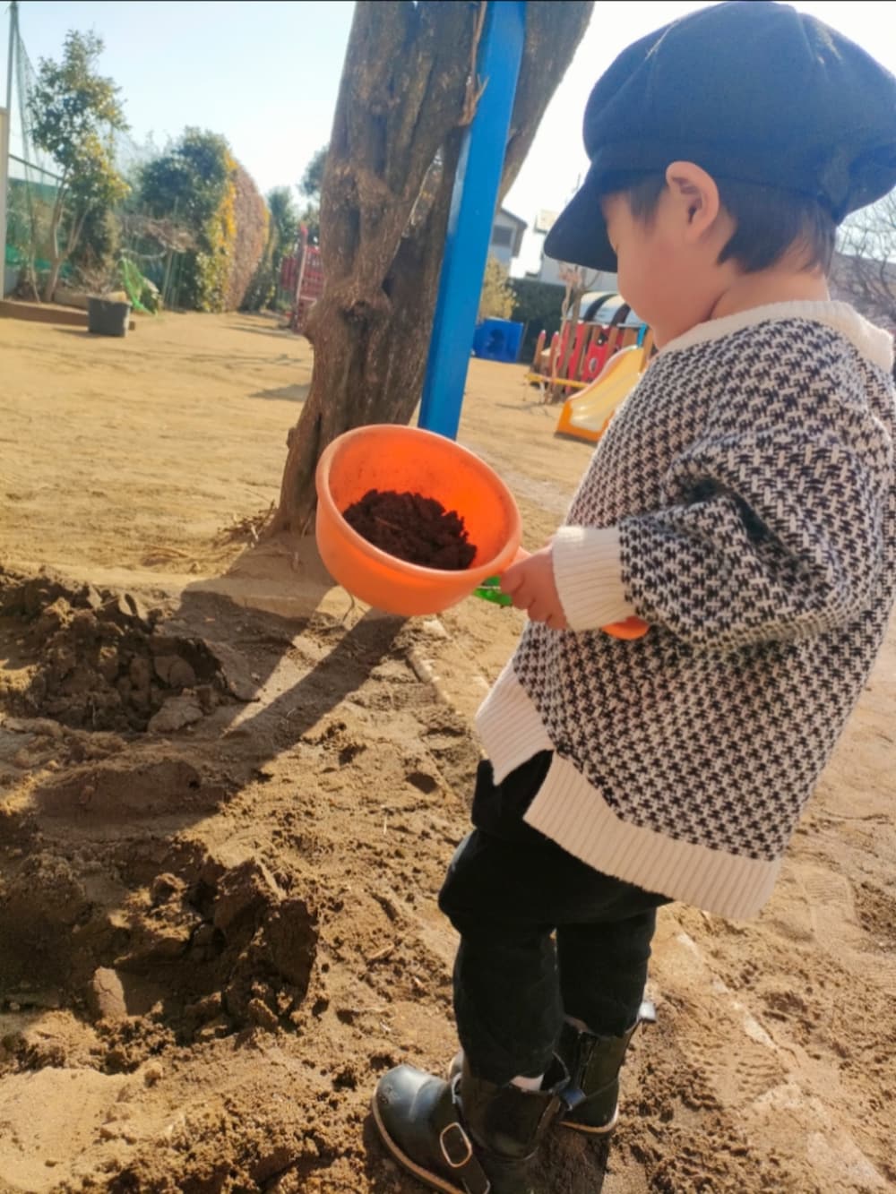 ホワイト系のカーディガン/ボレロ、ブラック系のその他パンツ、ブラック系のブーツを着用したキッズの冬コーディネートの2枚目の写真