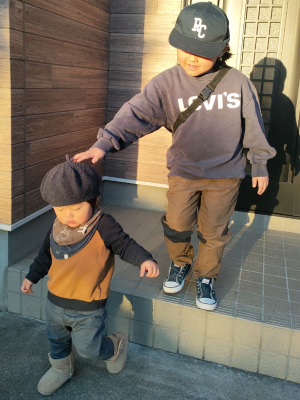 ブルー系のスウェット、ブラウン系のパンツ、ブルー系のスニーカーを着用したキッズの冬コーディネートの3枚目の写真