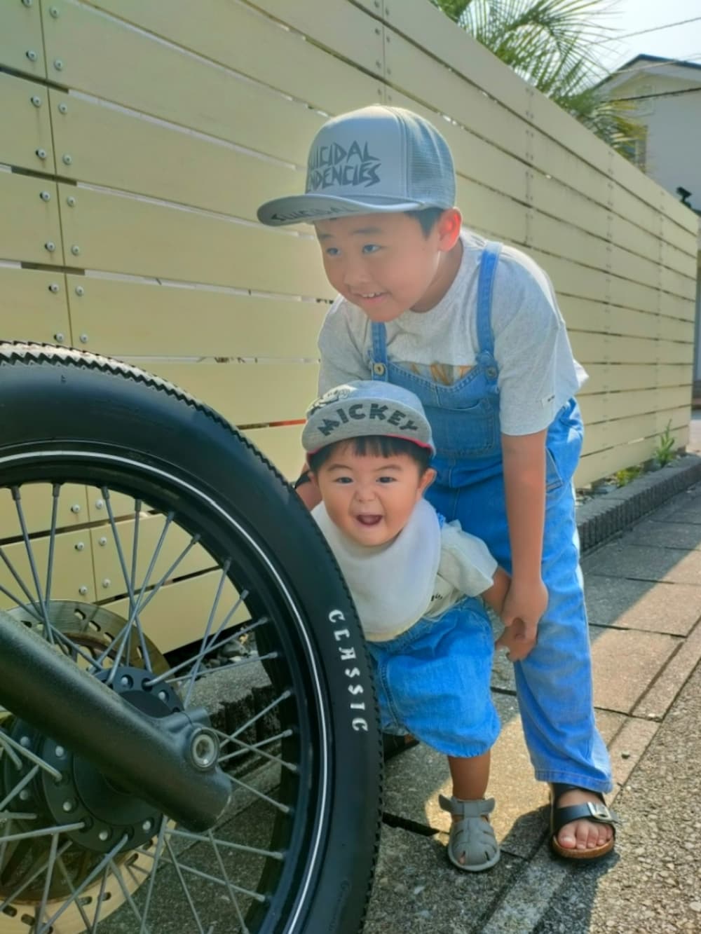 ブルー系のサロペット/オーバーオール、グレー系のTシャツ/カットソー、ブルー系のオールインワン・サロペットを着用したキッズの秋コーディネートの2枚目の写真