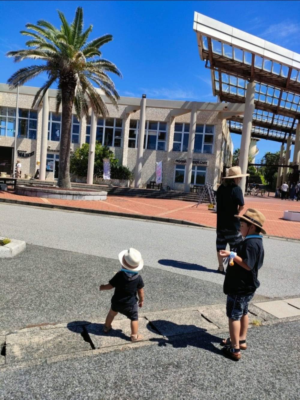 ブラック系のTシャツ/カットソー、ブラック系のパンツ、ブラック系のサンダルを着用したキッズの秋コーディネートの3枚目の写真