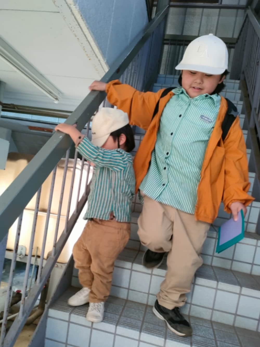 グリーン系のシャツ/ブラウス、ベージュ系のパンツ、ホワイト系のスニーカーを着用したキッズの冬コーディネートの2枚目の写真