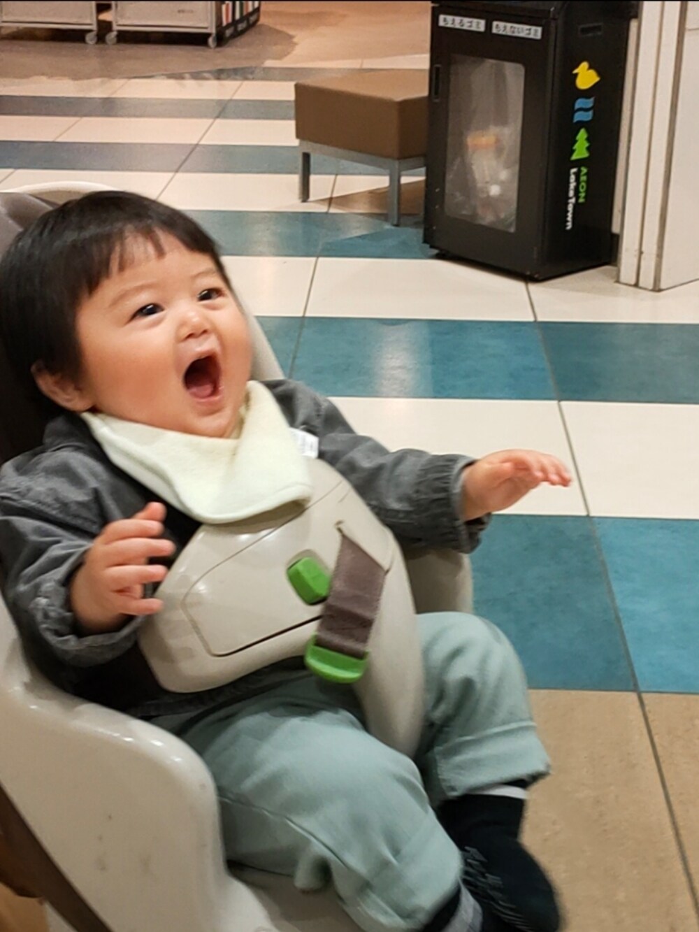 グリーン系のパンツ、ブラック系のスニーカー、グレー系のシャツ/ブラウスを着用したキッズの春コーディネートの4枚目の写真