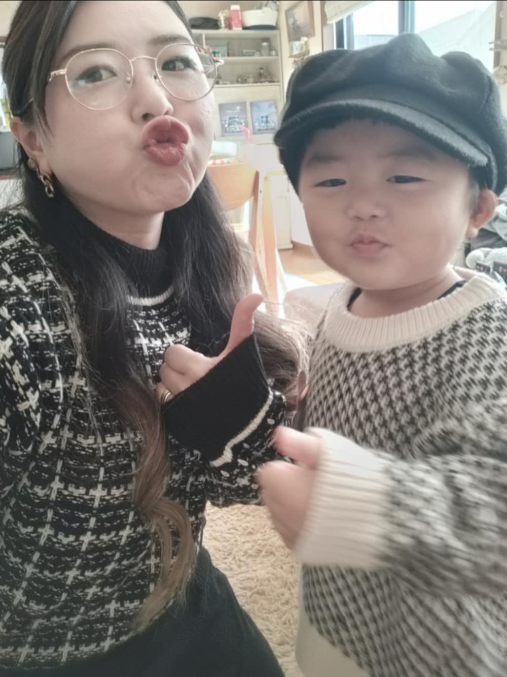 ホワイト系のカーディガン/ボレロ、ブラック系のその他パンツ、ブラック系のブーツを着用したキッズの冬コーディネートの5枚目の写真