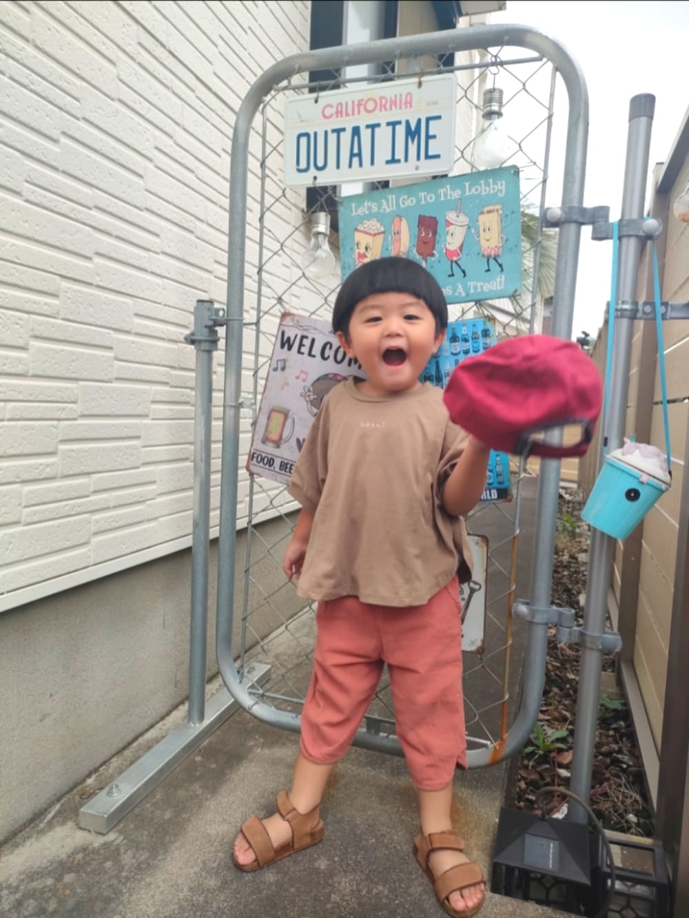 ブラウン系のTシャツ/カットソー、ブラウン系のサンダル、ベージュ系のセットアップを着用したキッズの夏コーディネートの3枚目の写真