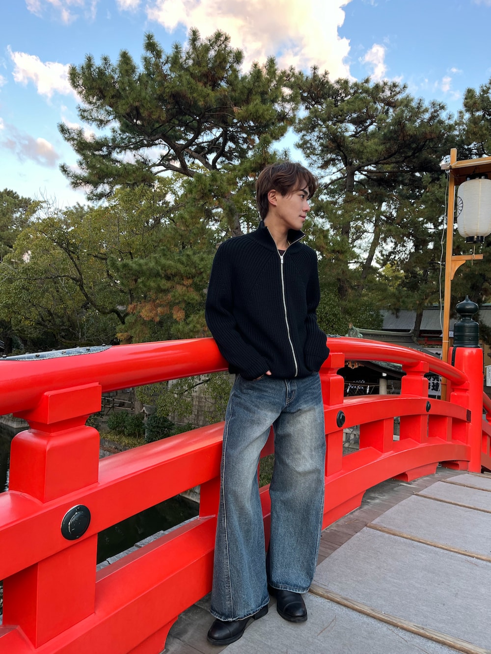 ブラック系のニット/セーター、ブルー系のデニムパンツ、ブラック系のブーツを着用したメンズの冬コーディネートの2枚目の写真