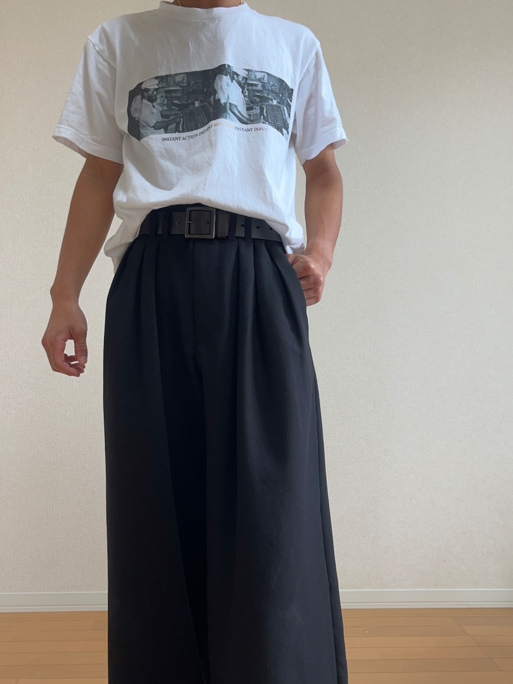 ホワイト系のTシャツ/カットソー、ブラック系のスラックス、ブラック系のブーツを着用したメンズの秋コーディネートの3枚目の写真