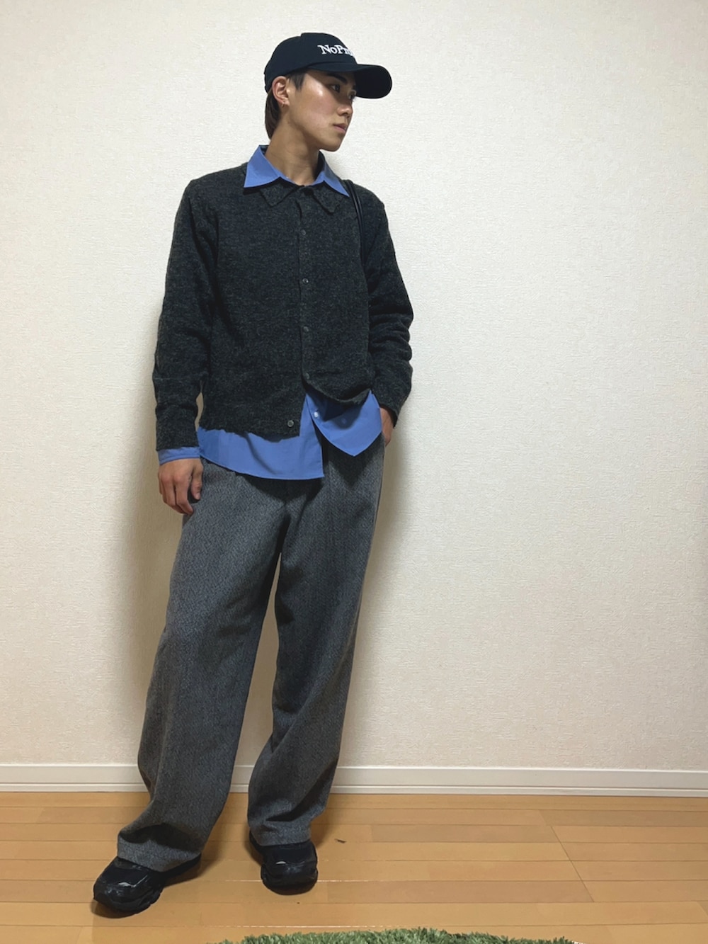 ブラック系のニット/セーター、グレー系のスラックス、ブルー系のシャツ/ブラウスを着用したメンズの秋コーディネートの2枚目の写真