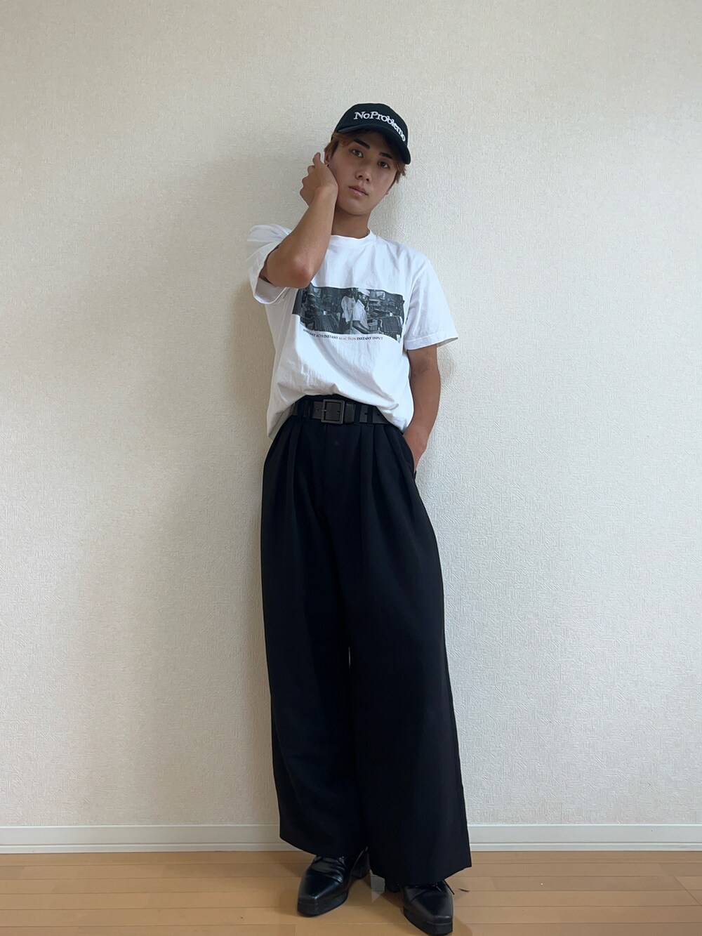 ホワイト系のTシャツ/カットソー、ブラック系のスラックス、ブラック系のブーツを着用したメンズの秋コーディネートの2枚目の写真