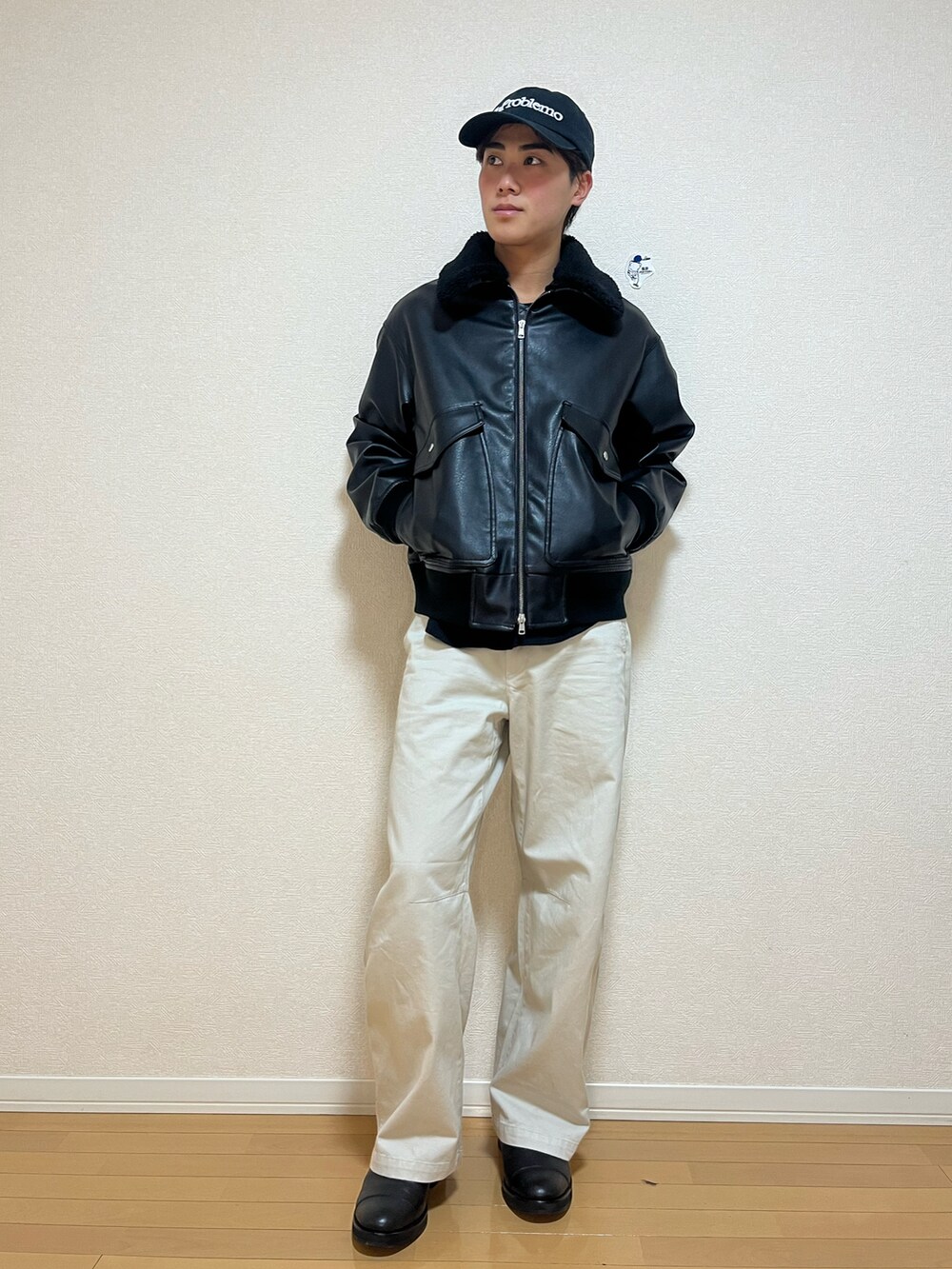 ブラック系のブルゾン、ホワイト系のパンツ、ブラック系のブーツを着用したメンズの冬コーディネートの2枚目の写真