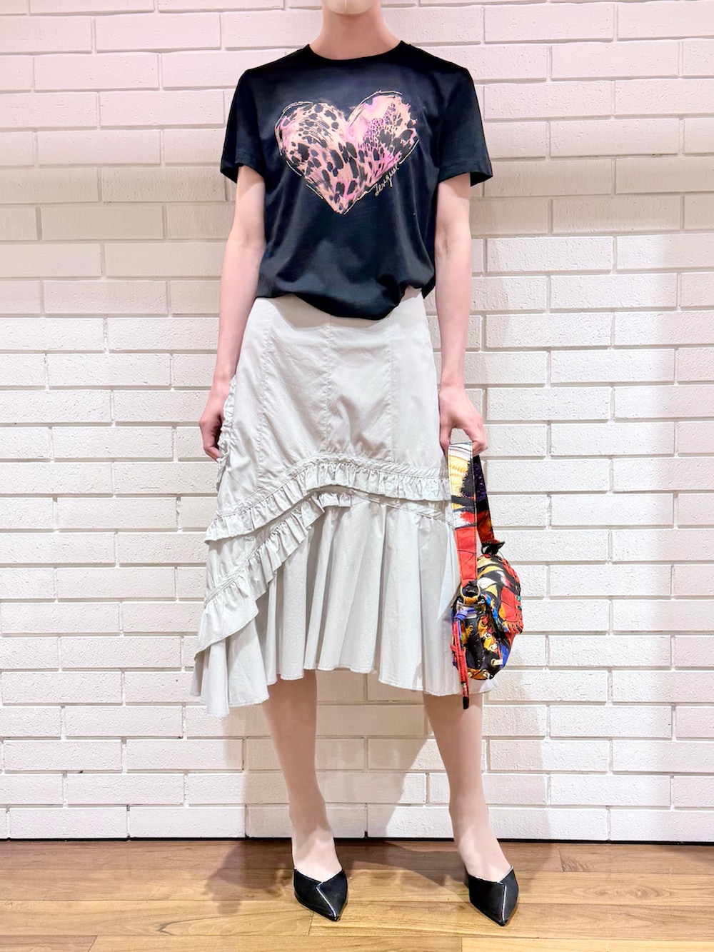 ブラック系のTシャツ/カットソー、ホワイト系のスカート、その他のハンドバッグを着用したレディースの夏コーディネートの2枚目の写真