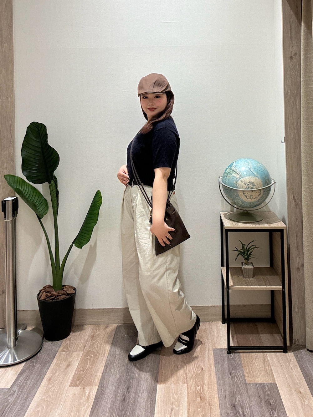 ブラック系のローファー、ホワイト系のその他パンツ、ブラウン系のショルダーバッグを着用したレディースの春コーディネートの2枚目の写真
