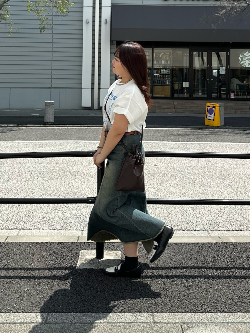 ブラウン系のショルダーバッグ、ブルー系のスカート、ホワイト系のTシャツ/カットソーを着用したレディースの春コーディネートの4枚目の写真