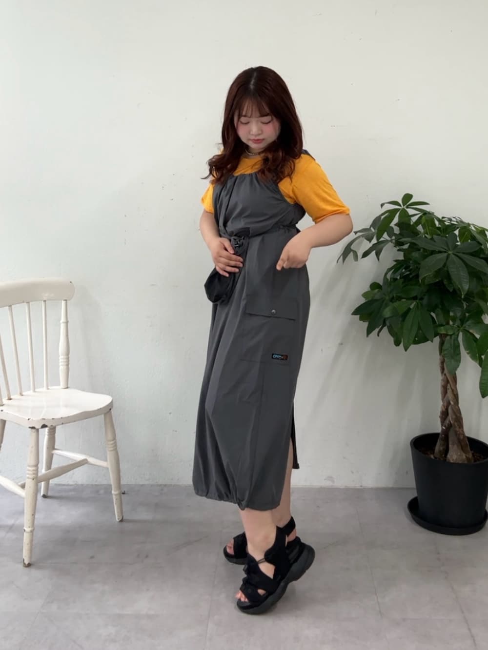 グレー系のワンピース、イエロー系のTシャツ/カットソー、ブラック系のサンダルを着用したレディースの夏コーディネートの3枚目の写真