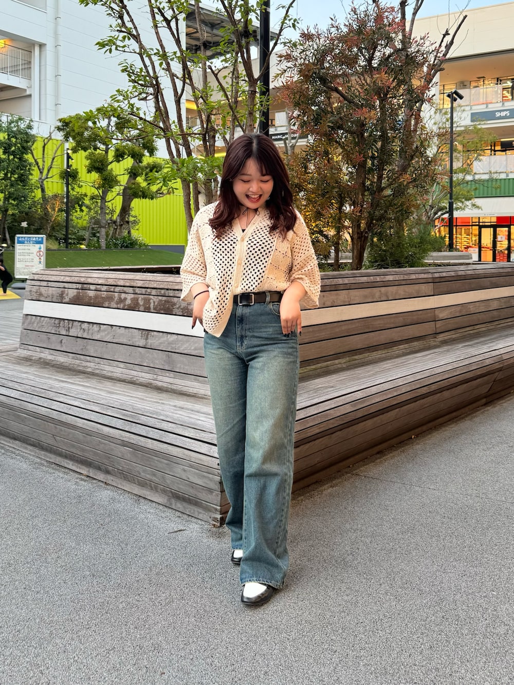 ブルー系のデニムパンツ、ホワイト系のシャツ/ブラウス、ブラック系のベルトを着用したレディースの春コーディネートの2枚目の写真