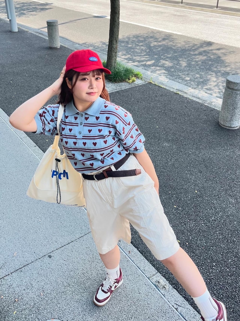 ブルー系のニット/セーター、ホワイト系のトートバッグ、ホワイト系のカーゴパンツを着用したレディースの夏コーディネートの3枚目の写真