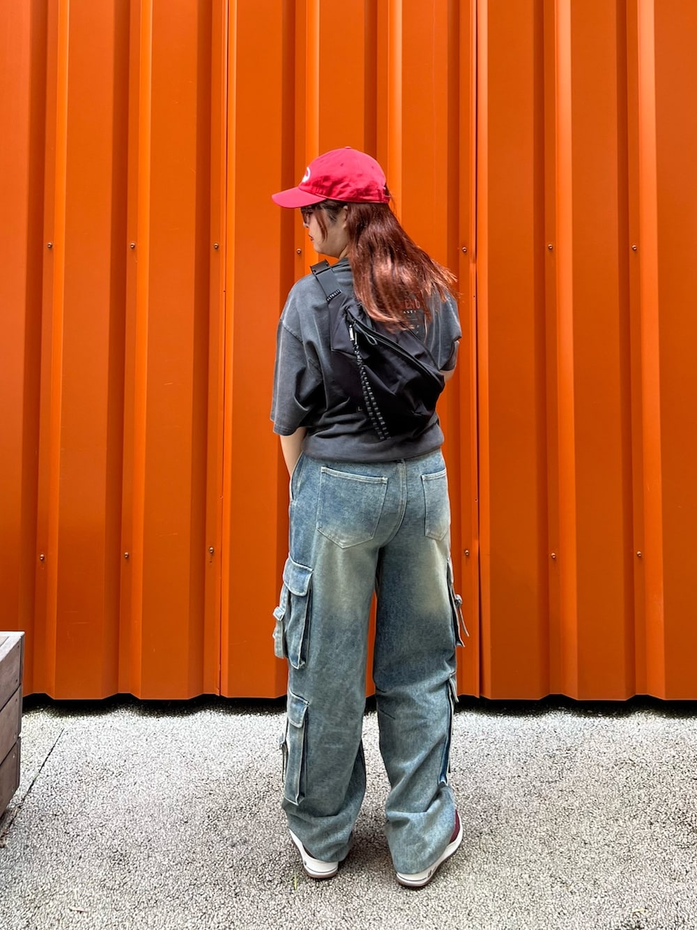 グレー系のTシャツ/カットソー、ブラック系のボディバッグ/ウエストポーチ、レッド系のキャップを着用したレディースの夏コーディネートの3枚目の写真