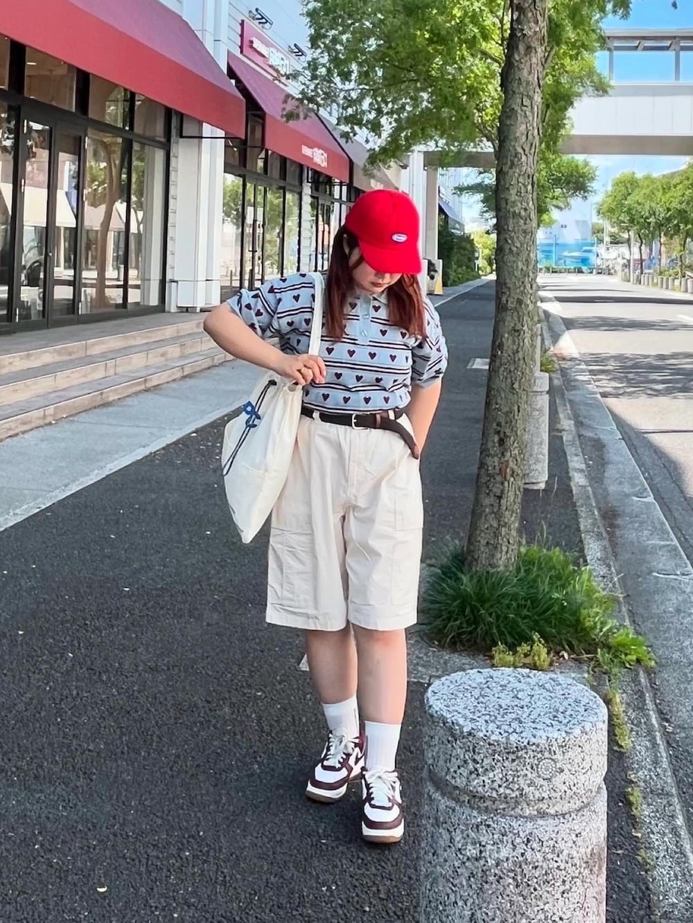 ブルー系のニット/セーター、ホワイト系のトートバッグ、ホワイト系のカーゴパンツを着用したレディースの夏コーディネートの2枚目の写真