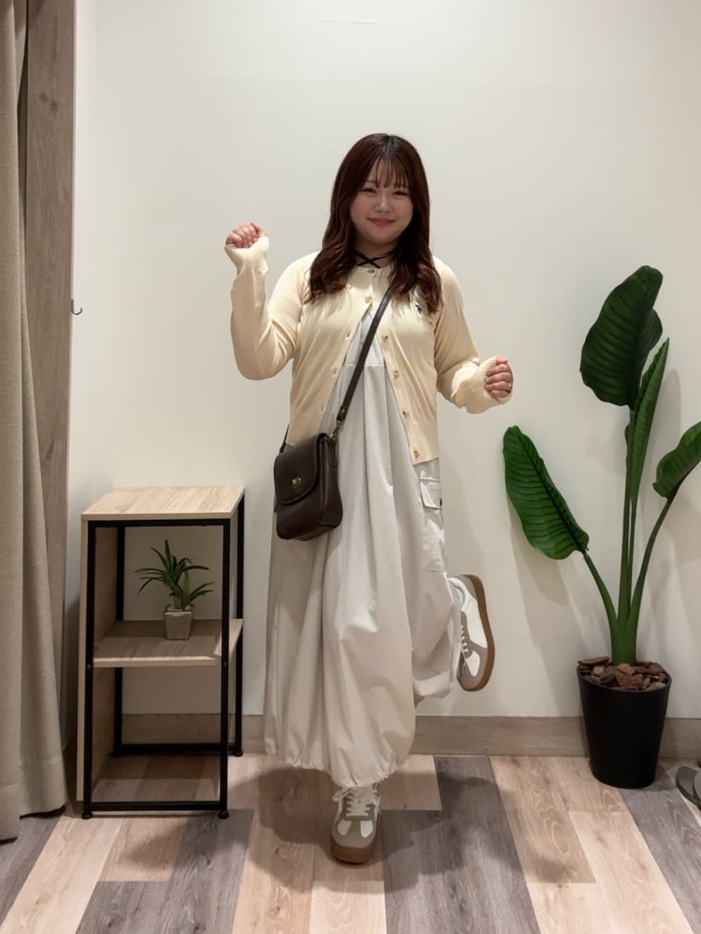 ホワイト系のワンピース、ベージュ系のスニーカー、ブラウン系のショルダーバッグを着用したレディースの夏コーディネートの3枚目の写真