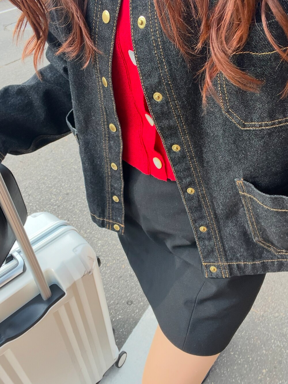 ブラック系のブルゾン、ブラック系のブーツ、レッド系のトップスを着用したレディースの春コーディネートの2枚目の写真