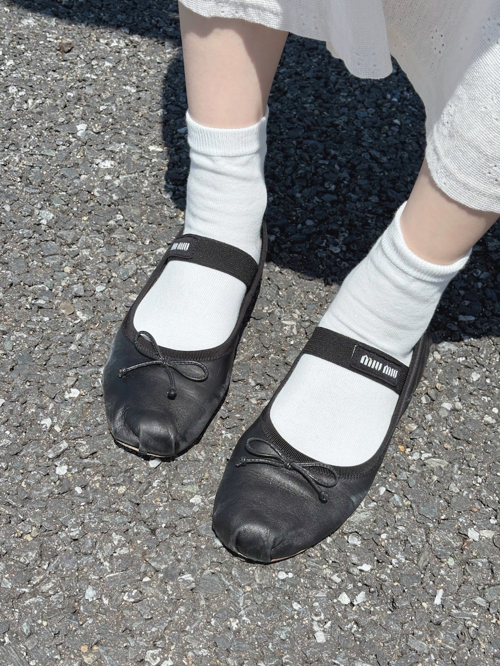 ブラック系のバレエシューズ、ホワイト系のワンピース、シルバー系のショルダーバッグを着用したレディースの春コーディネートの2枚目の写真